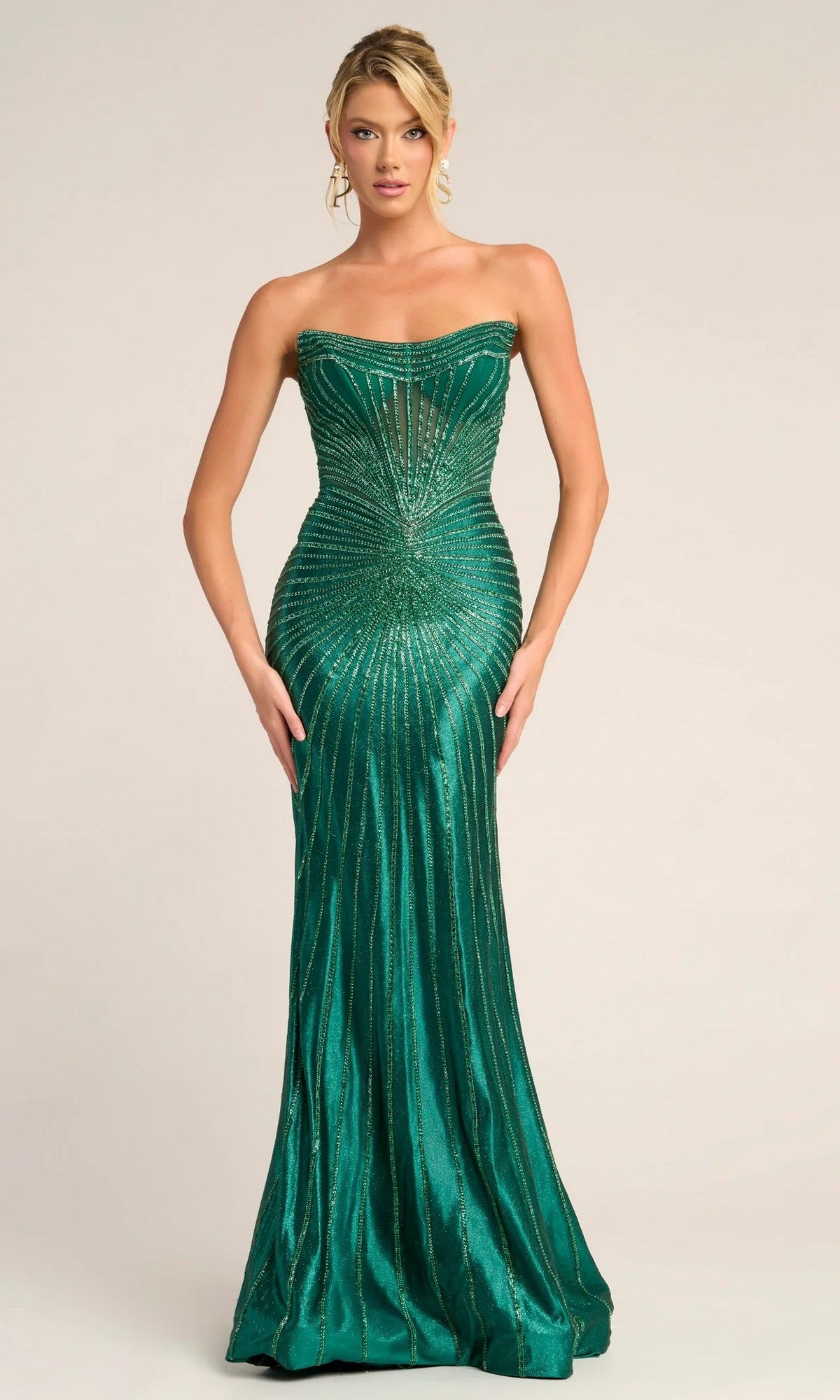 A woman wears the Portia and Scarlett PS26250 long formal dress, a strapless emerald green beaded gown with shimmering vertical and radiating lines, standing against a plain background.